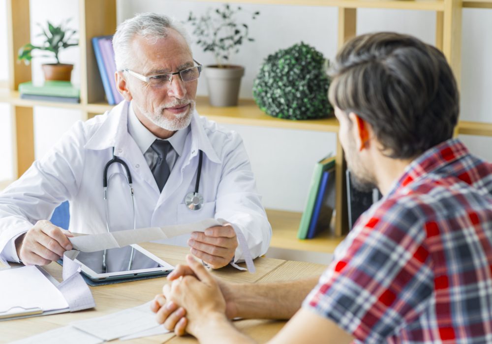 elderly-doctor-listening-young-patient
